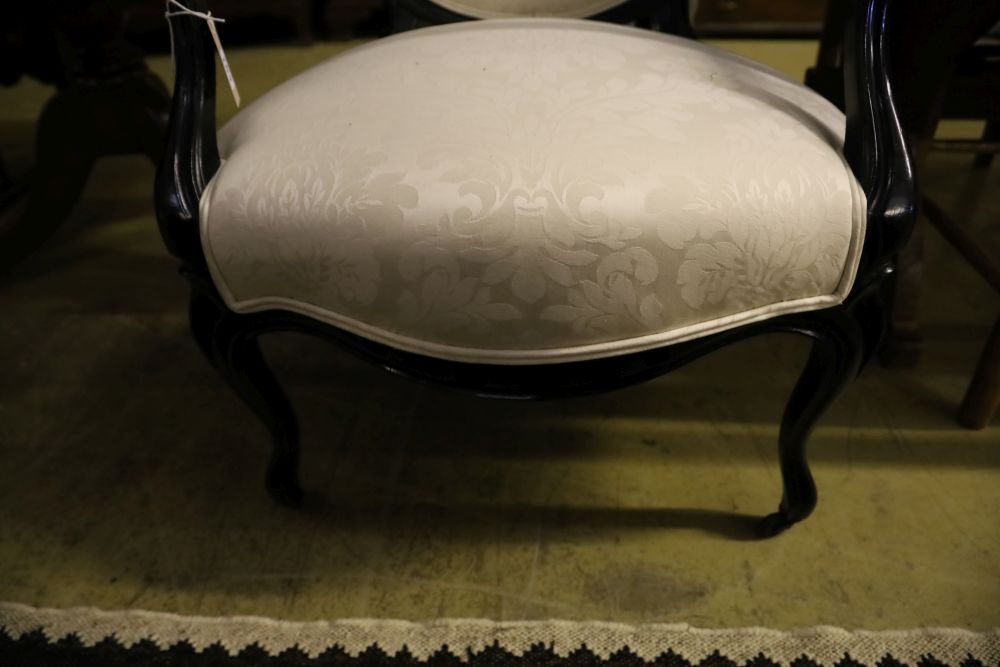 A pair of Louis XV style ebonised open armchairs, width 63cm, depth 50cm, height 100cm